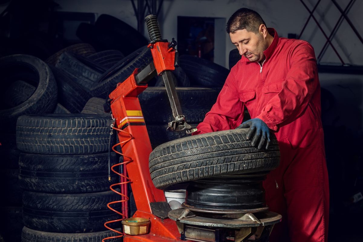 mechanic replace tyre on wheel in workshop 